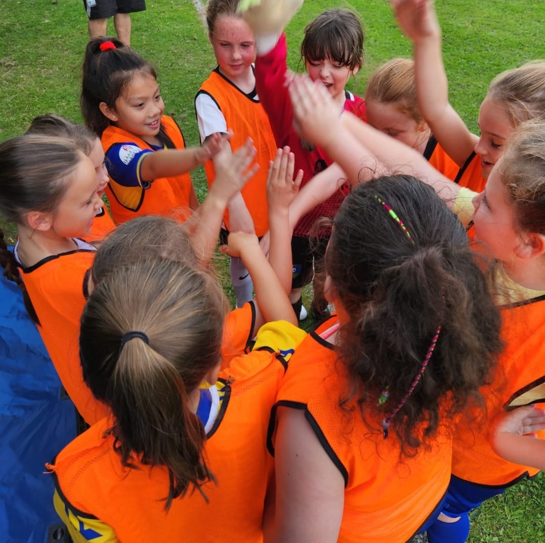 Girls football players in a team huddle